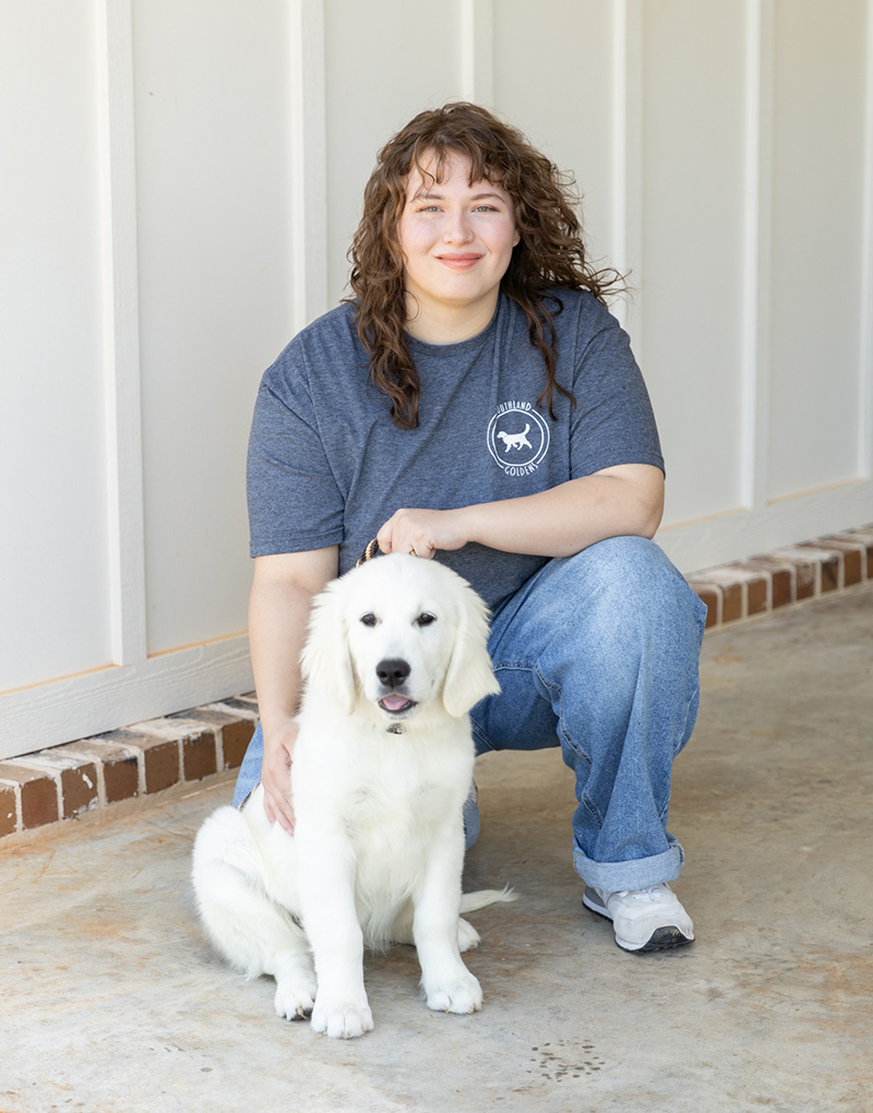 a woman holding a dog posing for the camera