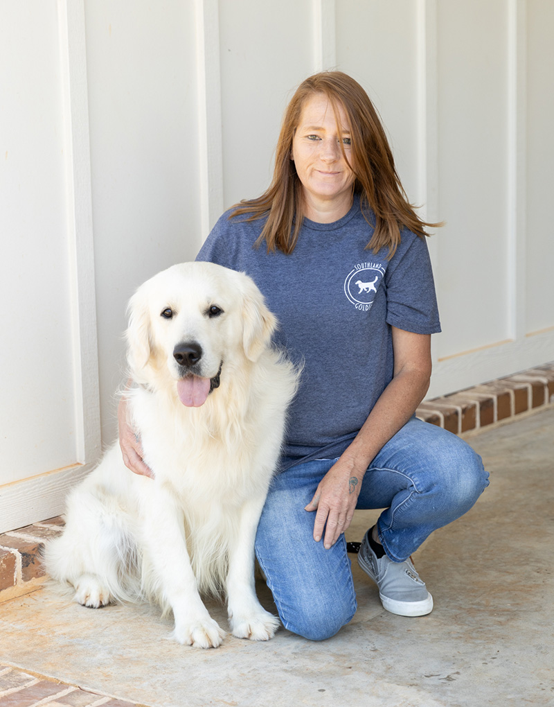 a person holding a dog posing for the camera